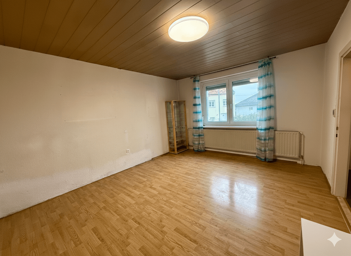 Helles Zimmer mit Holzboden, Holzdecke und Fenster mit Blick nach draußen.