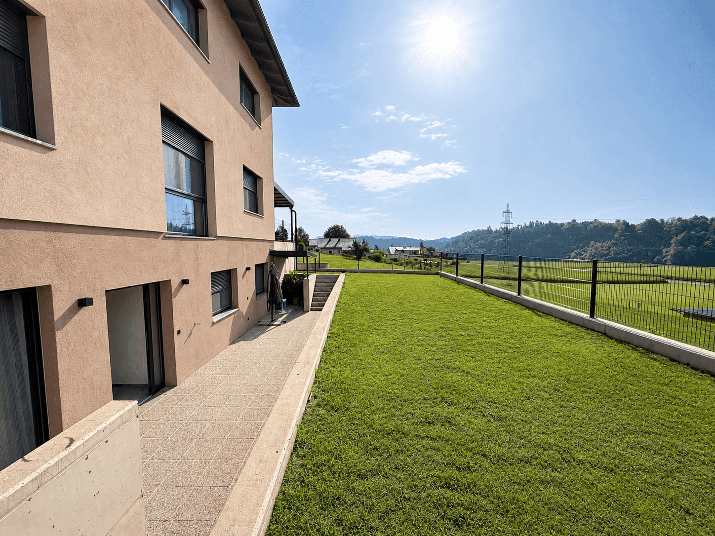 Großer, gepflegter Rasenbereich neben dem Haus mit sonniger Ausrichtung und freiem Blick.