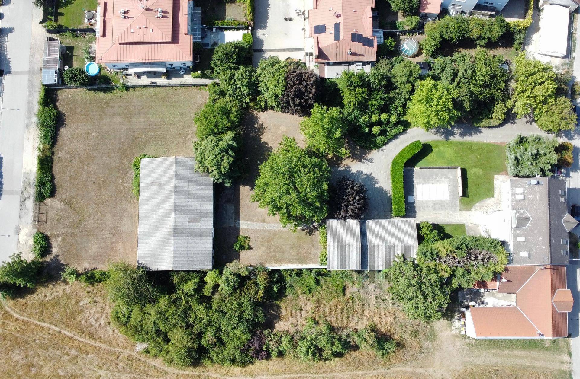 Übersicht aus der Vogelperspektive mit Gebäuden, Grünflächen und angrenzenden Wohnhäusern.