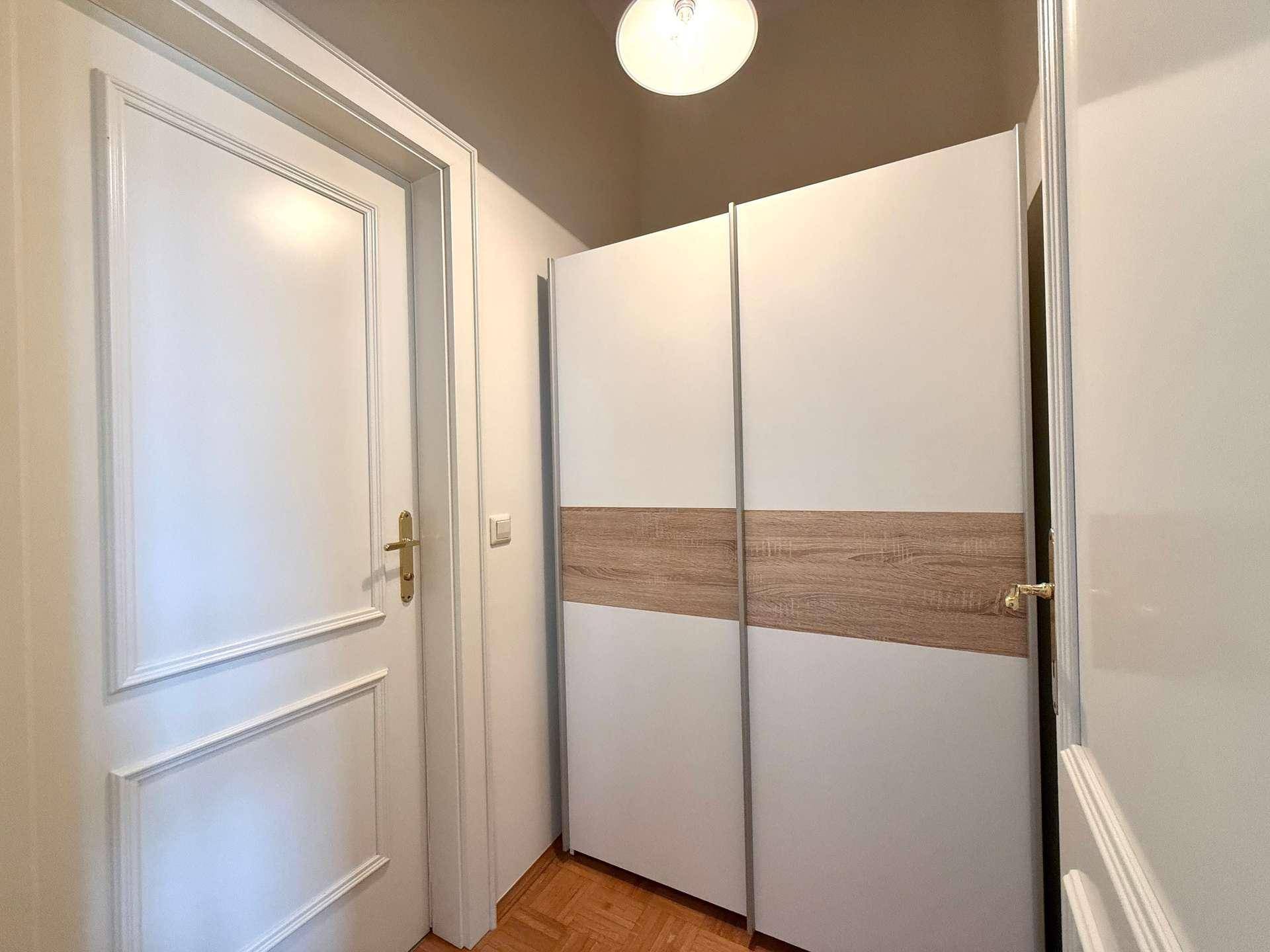 Heller Flur mit modernem Einbauschrank und weißer Tür, bietet praktischen Stauraum.