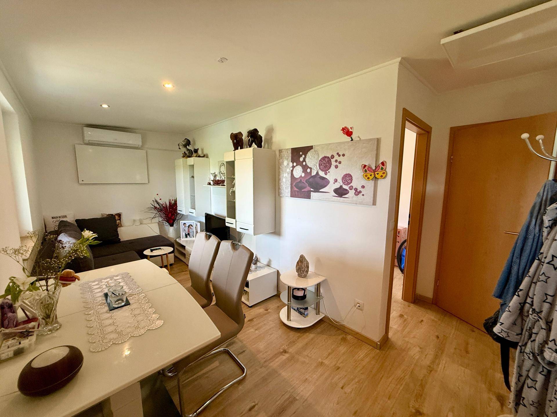 Gemütlicher Wohn- und Essbereich mit Sofa, Esstisch und moderner Dekoration.