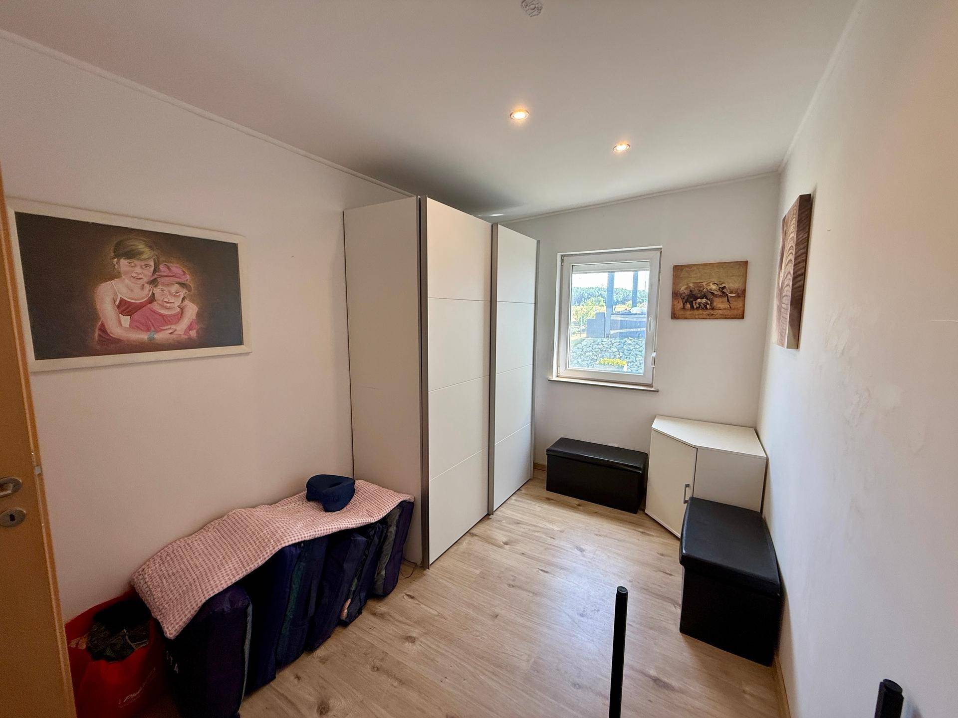 Kleines Zimmer mit Kleiderschränken und Fenster, ideal als Gäste- oder Arbeitszimmer.