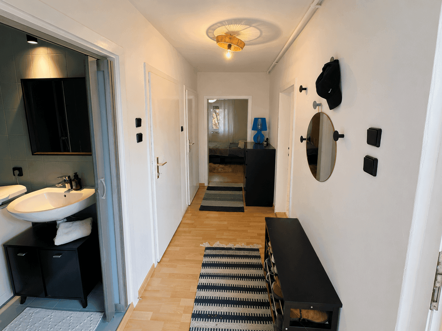 Heller Flur mit Holzboden, Garderobe und Zugang zu verschiedenen Räumen.