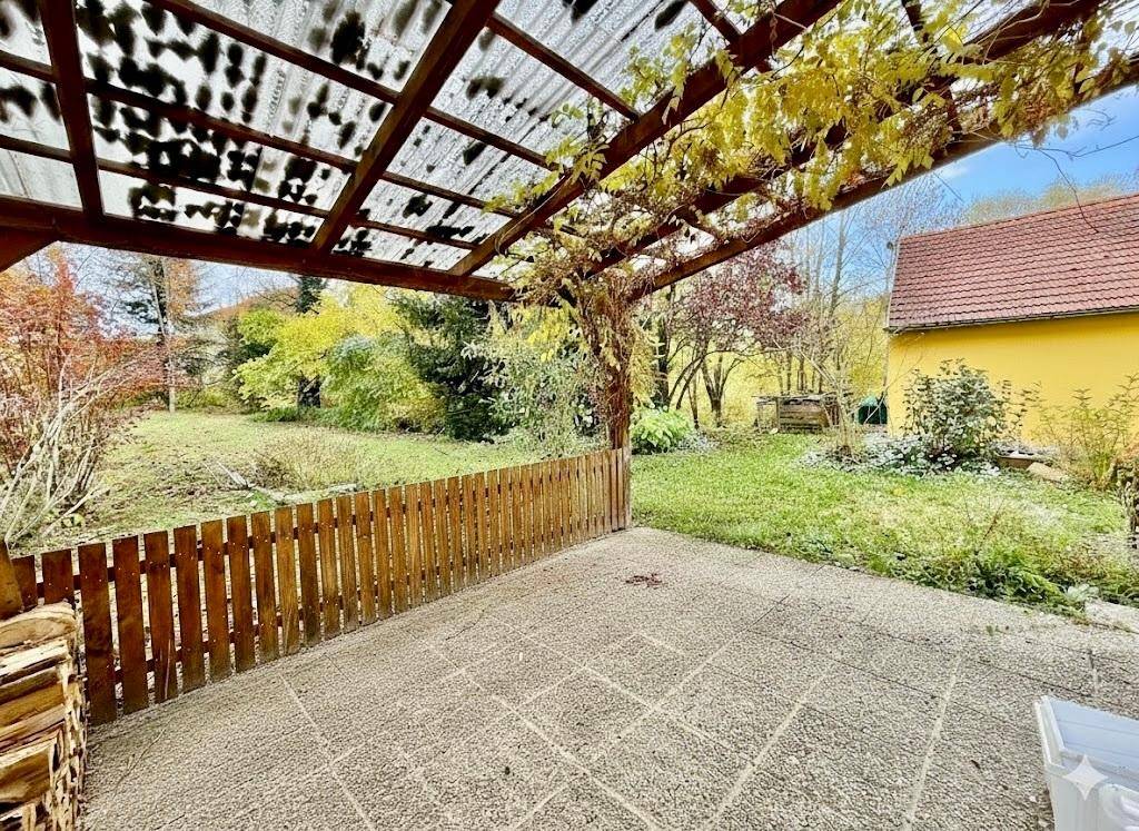 Gepflasterte Terrasse mit Pergola und Blick auf den weitläufigen grünen Garten.