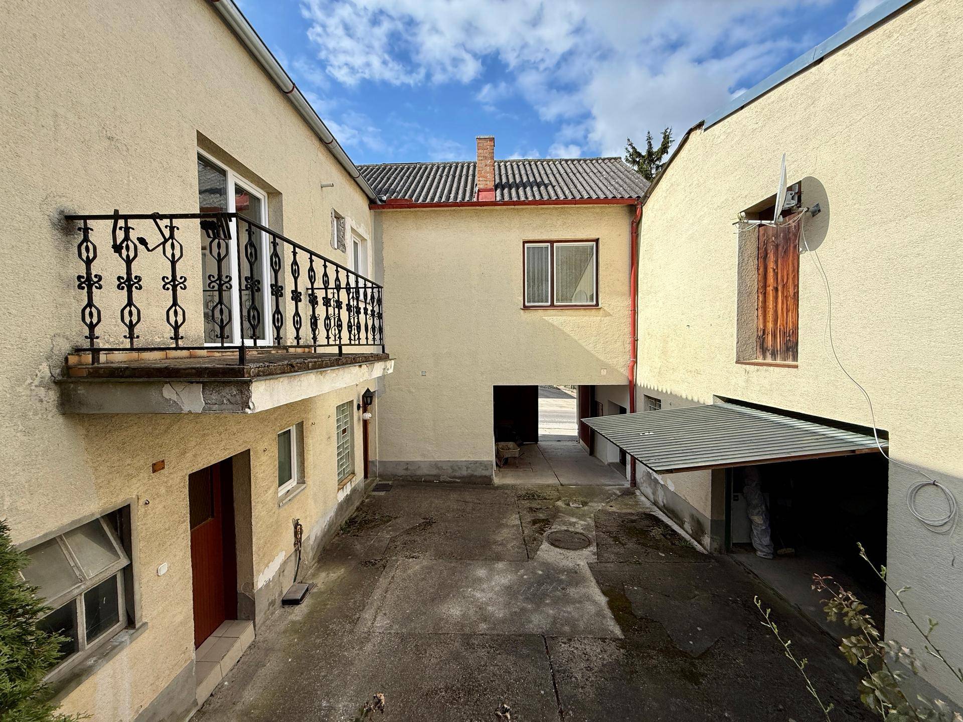 Innenhof mit einem kleinen Balkon und Zugang zu verschiedenen Gebäudeteilen.