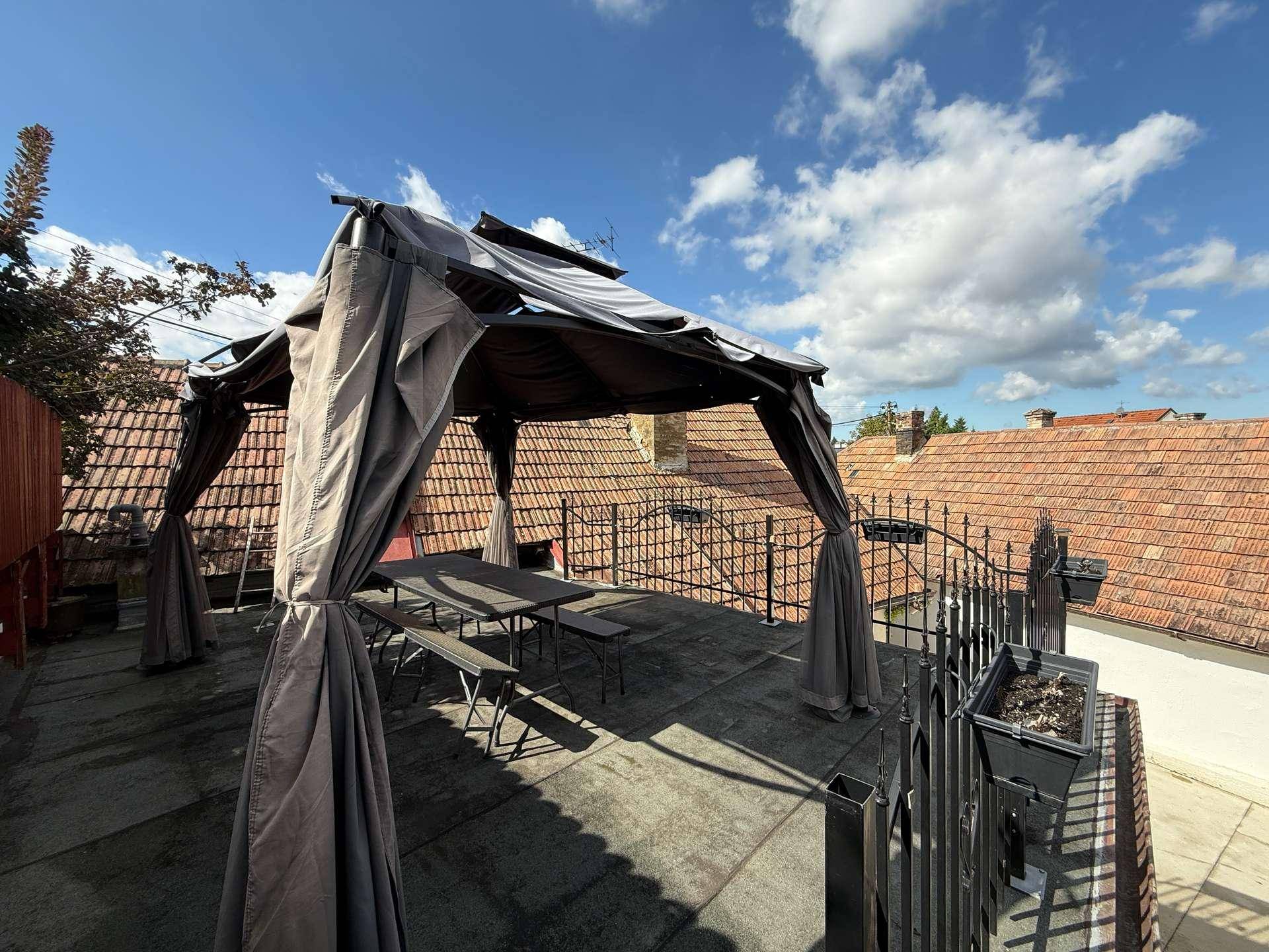 Dachterrasse mit Pavillon, Sitzgelegenheiten und Blick über die Dächer der Nachbarschaft.