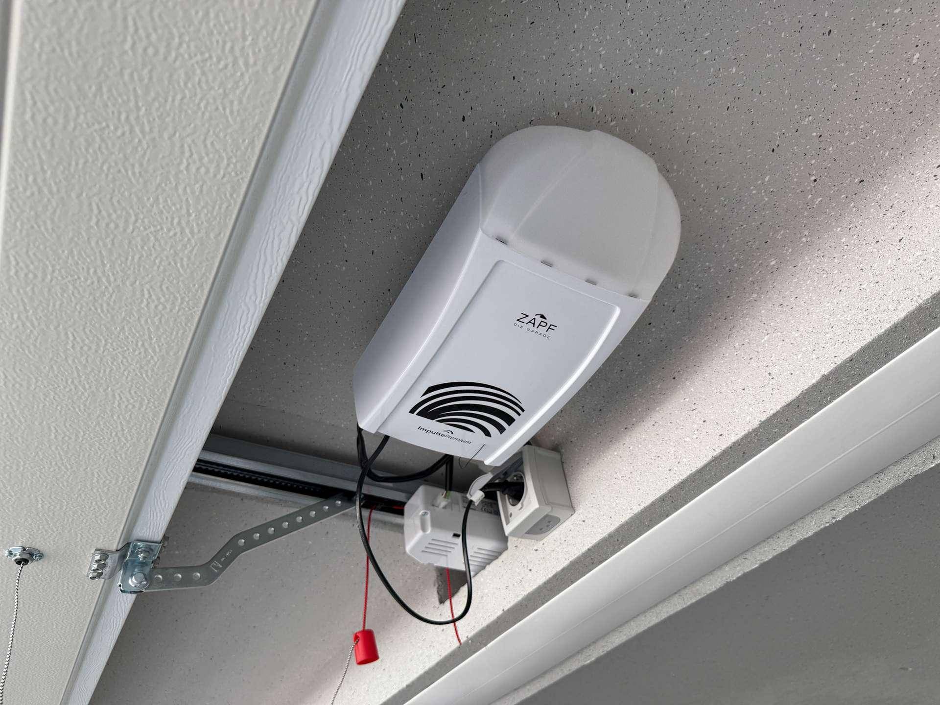 Nahaufnahme des automatischen Garagentorantriebs an der Decke der Box.