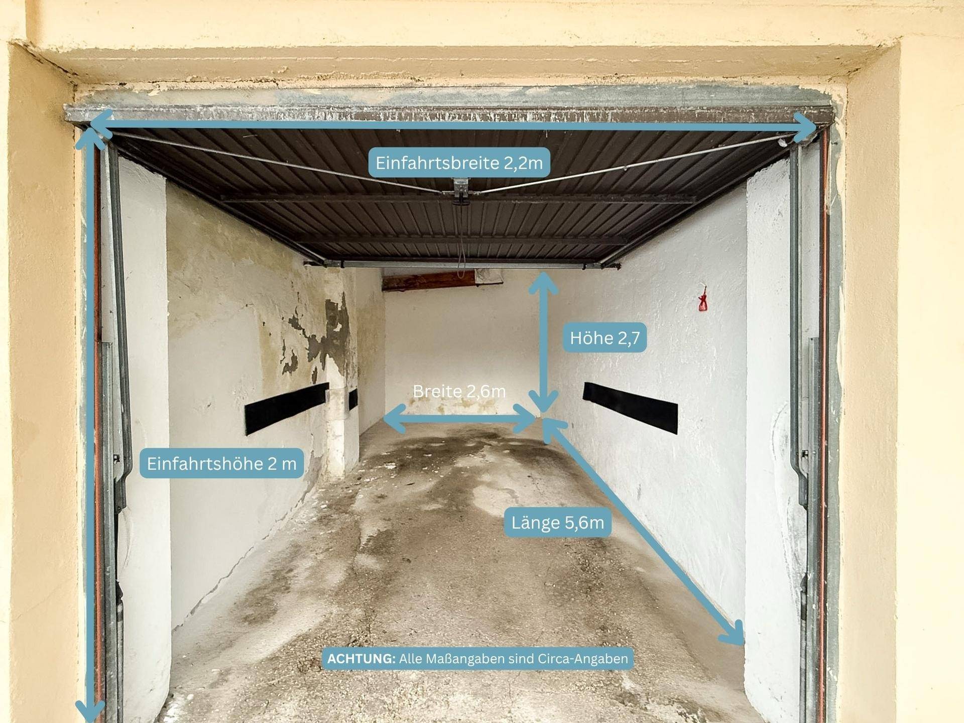 Innenansicht einer geräumigen Garage mit Betonboden und angegebenen Maßen.