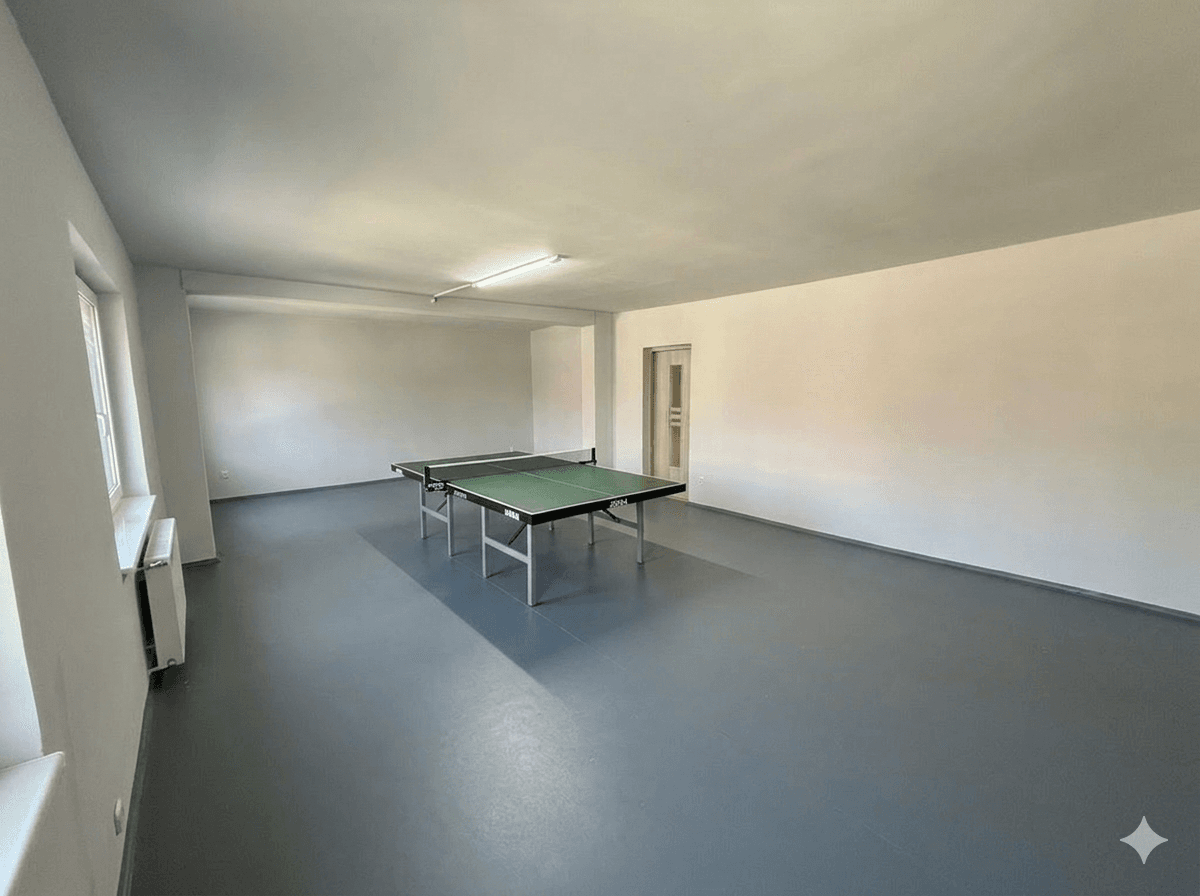 Großer Raum mit Tischtennisplatte, ideal für Sport und Freizeitaktivitäten.