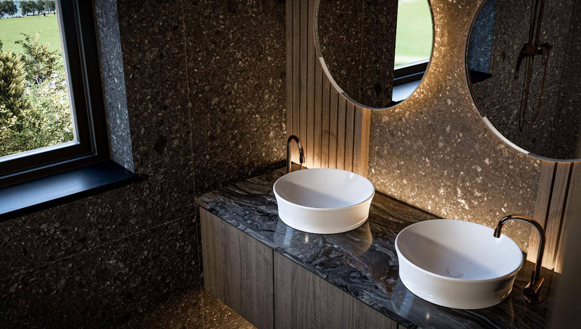 Elegantes Badezimmer mit Doppelwaschbecken, dunklen Steinplatten und runden Spiegeln.