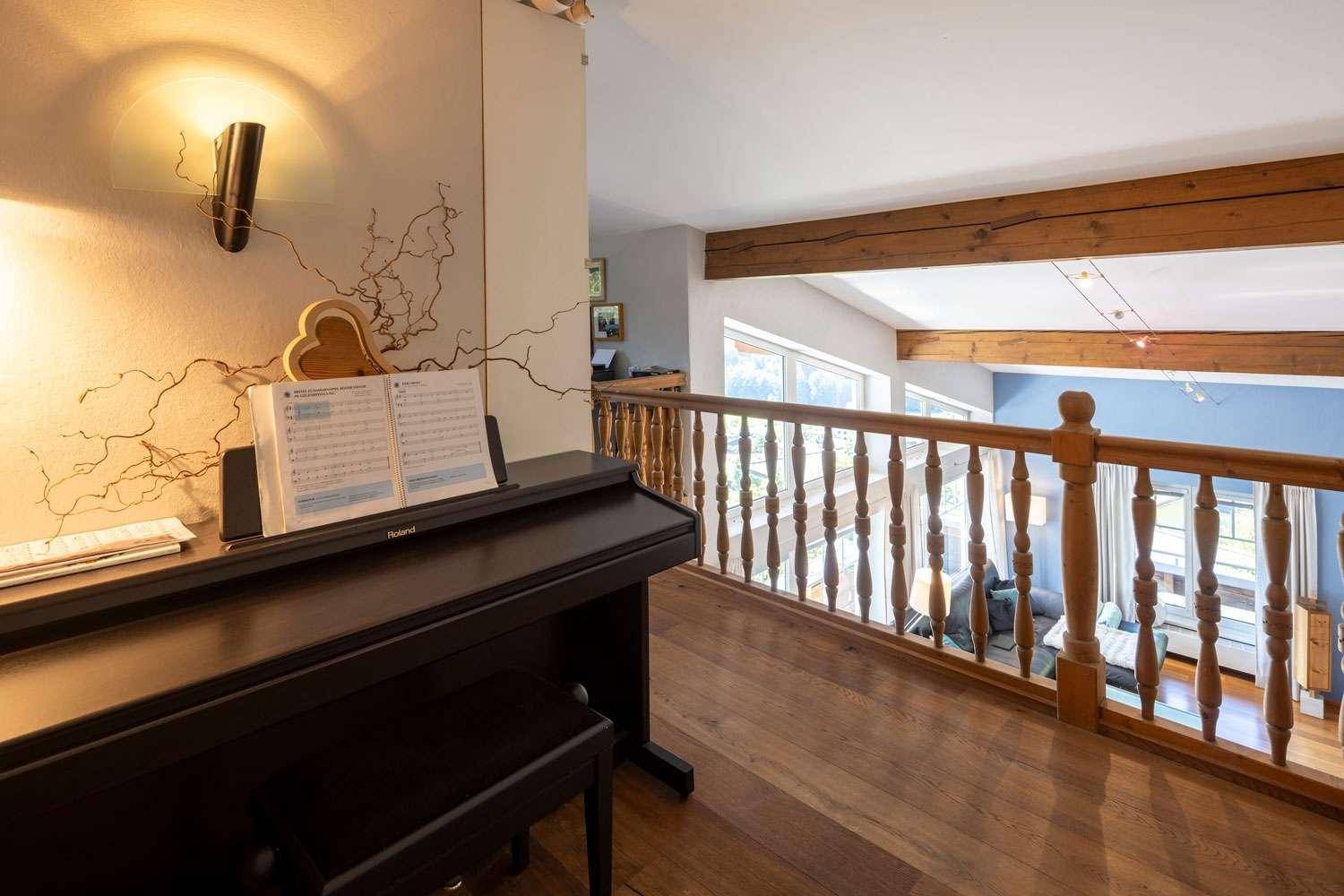Musikbereich auf der Galerie mit Klavier und weitem Blick in den Wohnraum.