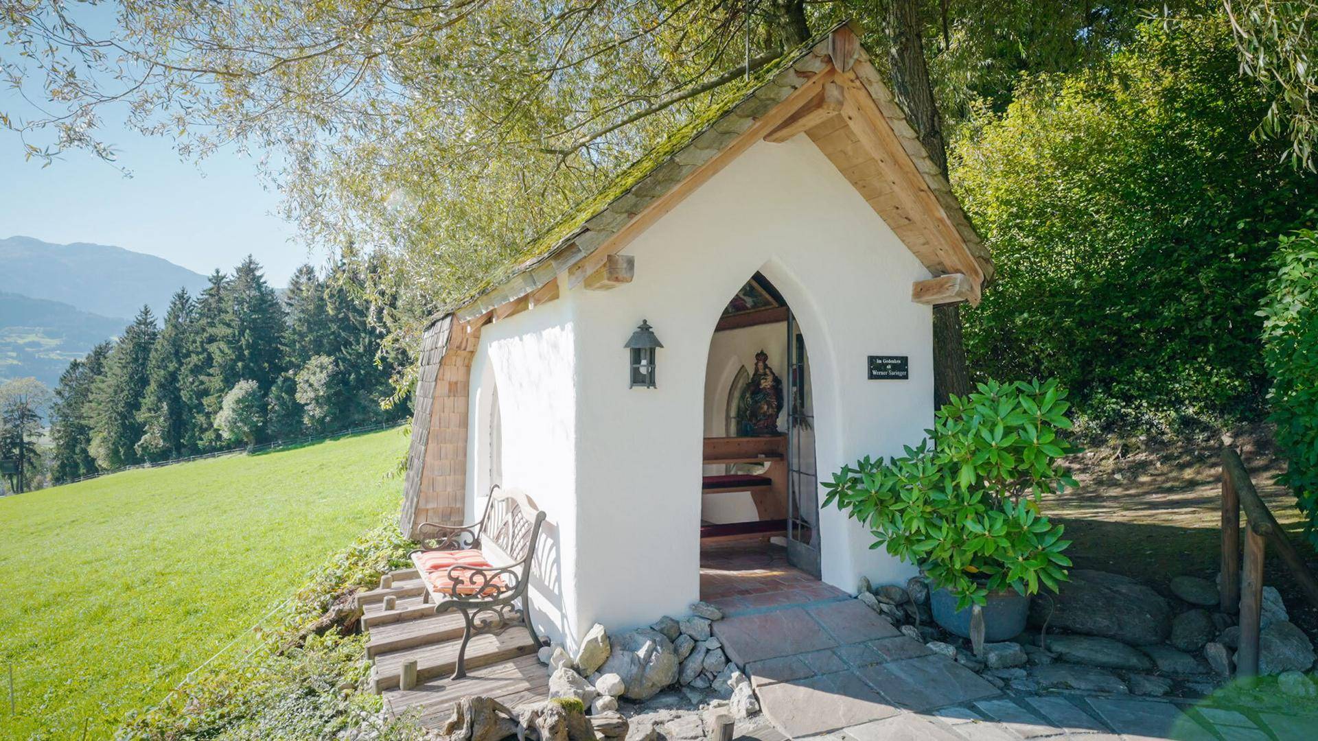 Malerische kleine Kapelle auf dem Grundstück, umgeben von grüner Natur.