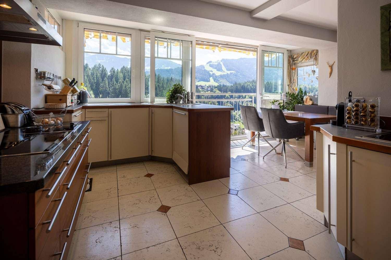 Helle Küche mit modernen Geräten und einem beeindruckenden Panoramablick auf die Berge.