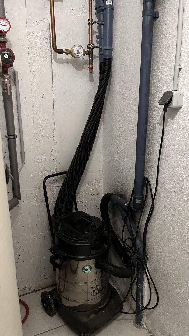 Hauswirtschaftsraum mit Zentralstaubsaugeranlage und sichtbaren Leitungen.