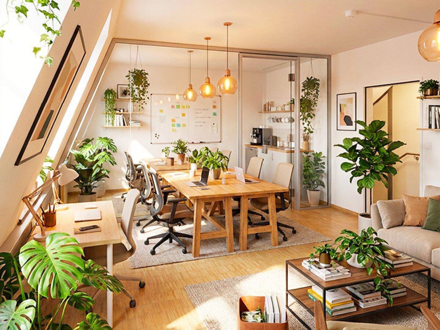 Modernes Büro mit vielen Pflanzen, Holztischen und einem Konferenzbereich hinter Glaswänden, gut beleuchtet.