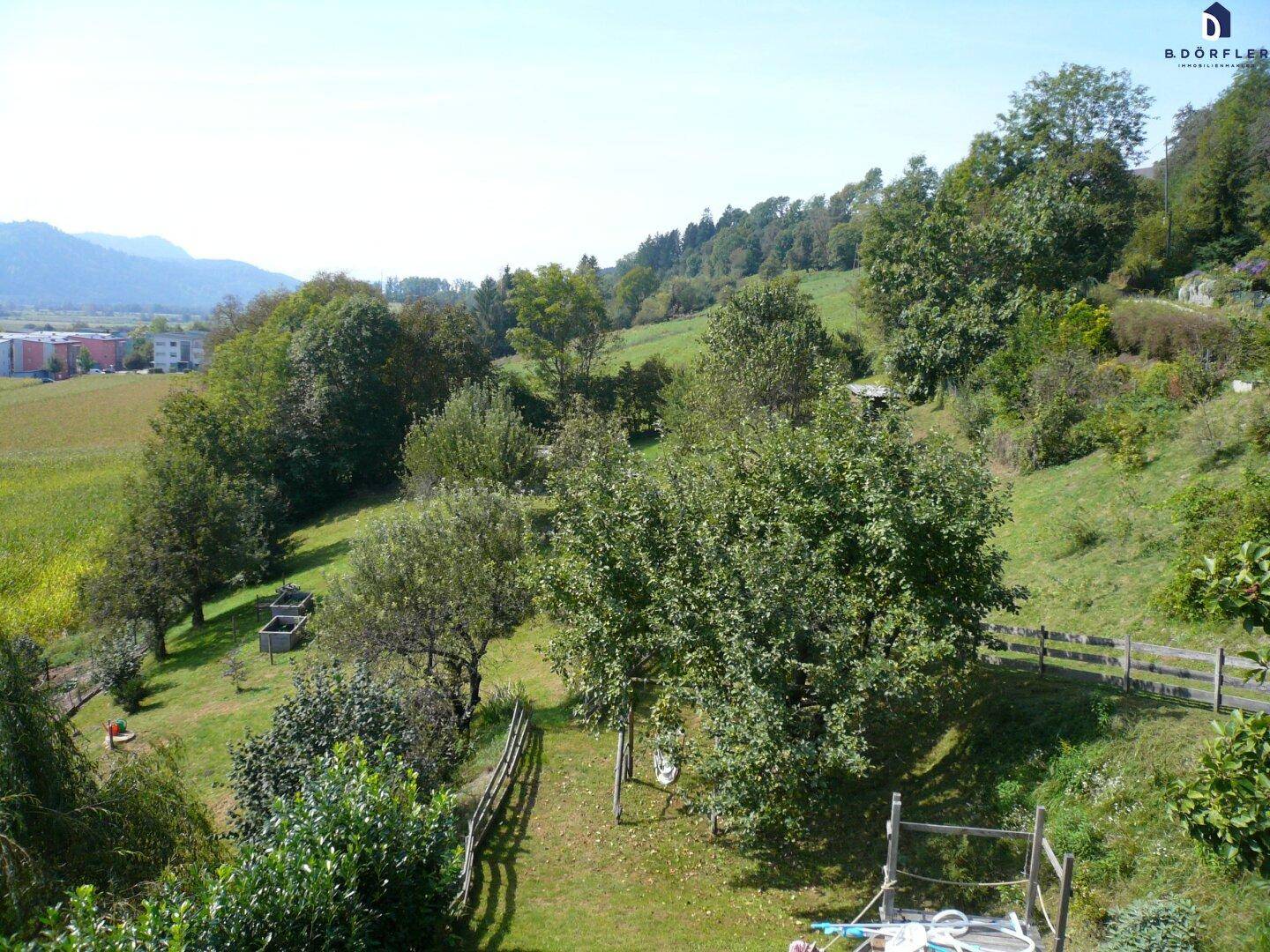 Großer Garten mit Obstbäumen und einem weiten Blick über die grüne Hügellandschaft.