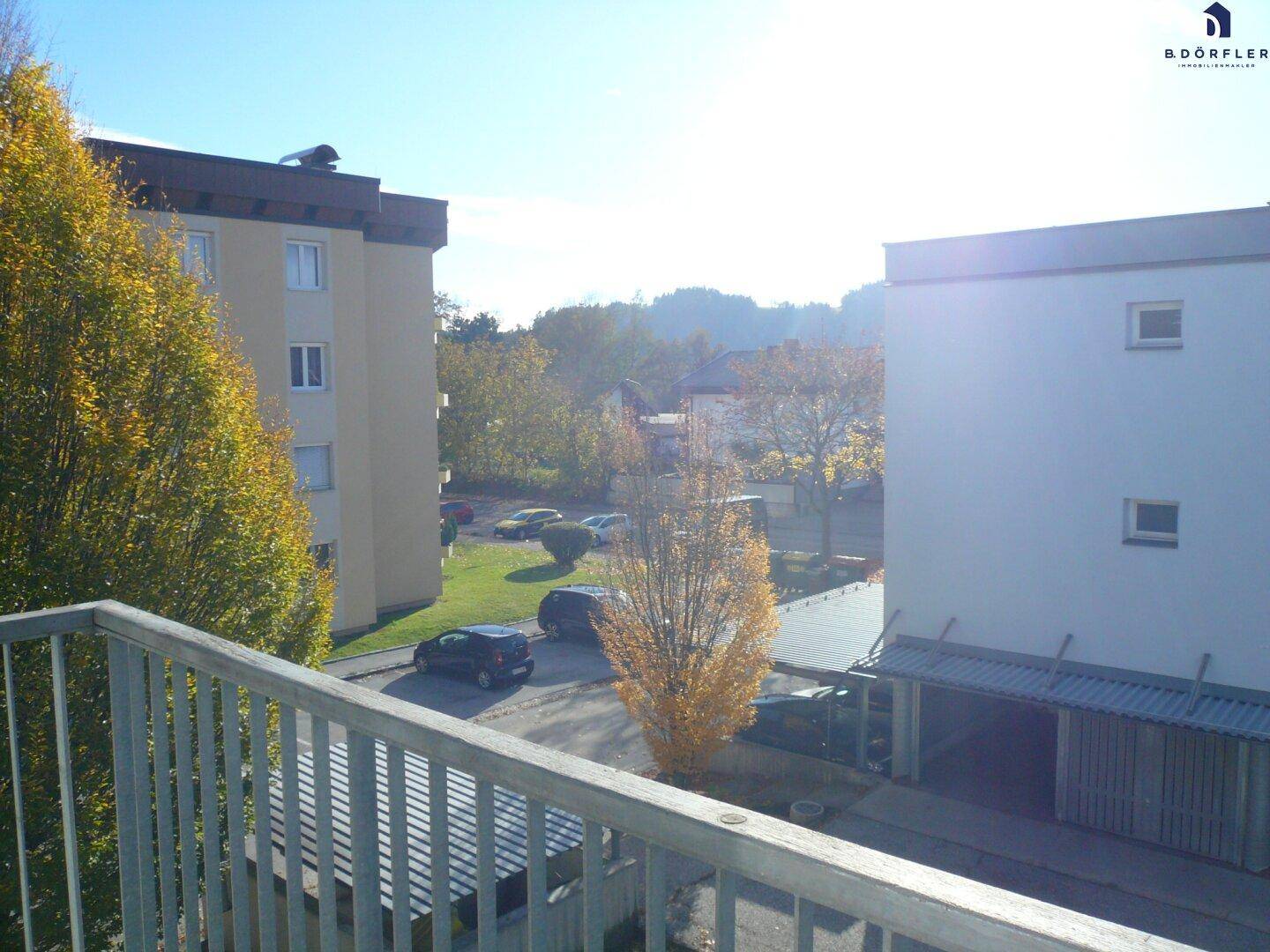 Blick vom Balkon auf die umliegenden Gebäude und Parkplätze.