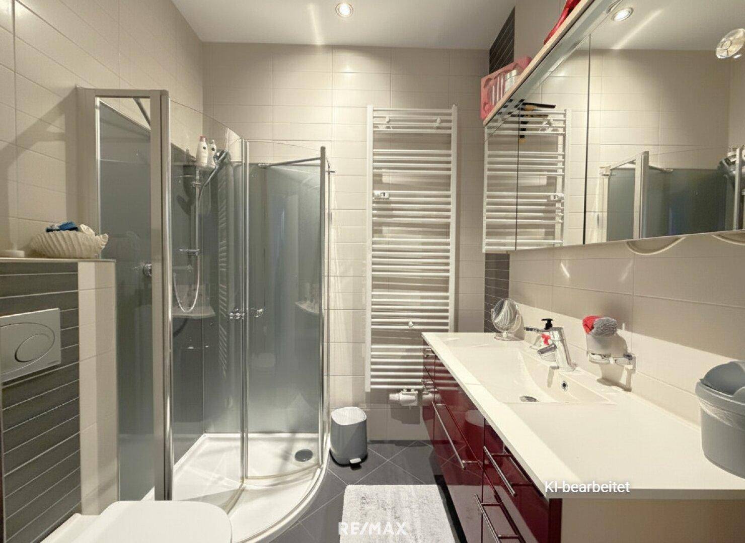 Modernes Badezimmer mit Duschkabine, Einzelwaschbecken und beheiztem Handtuchhalter.
