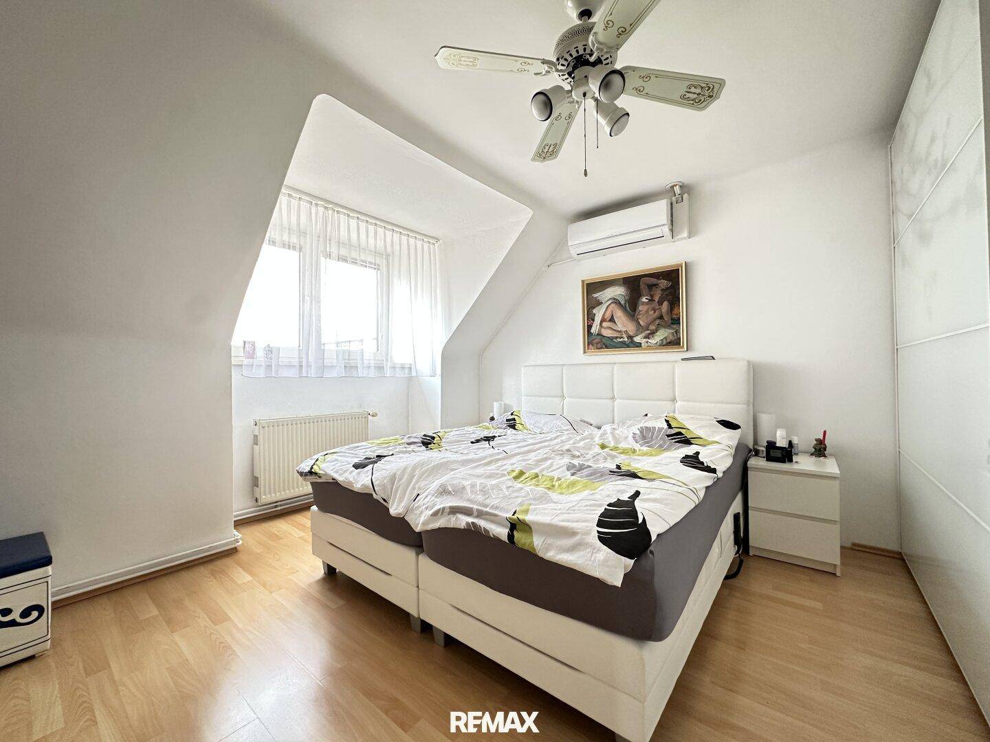 Gemütliches Schlafzimmer mit Doppelbett, Dachschräge, Deckenventilator und Klimaanlage.