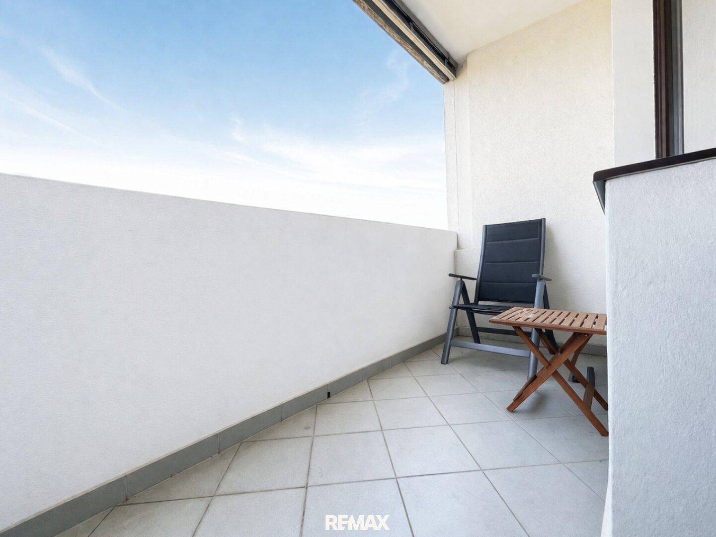 Kleiner Balkon mit Fliesenboden und einfacher Bestuhlung für entspannte Stunden.
