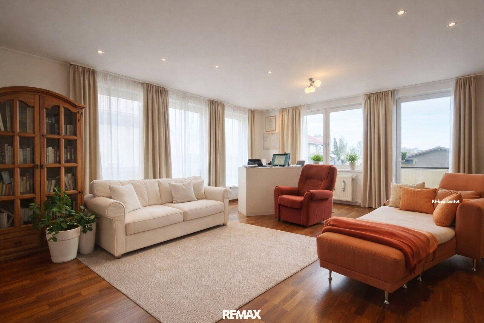 Geräumiges Wohnzimmer mit großen Fenstern, Parkettboden und bequemen Sofas.