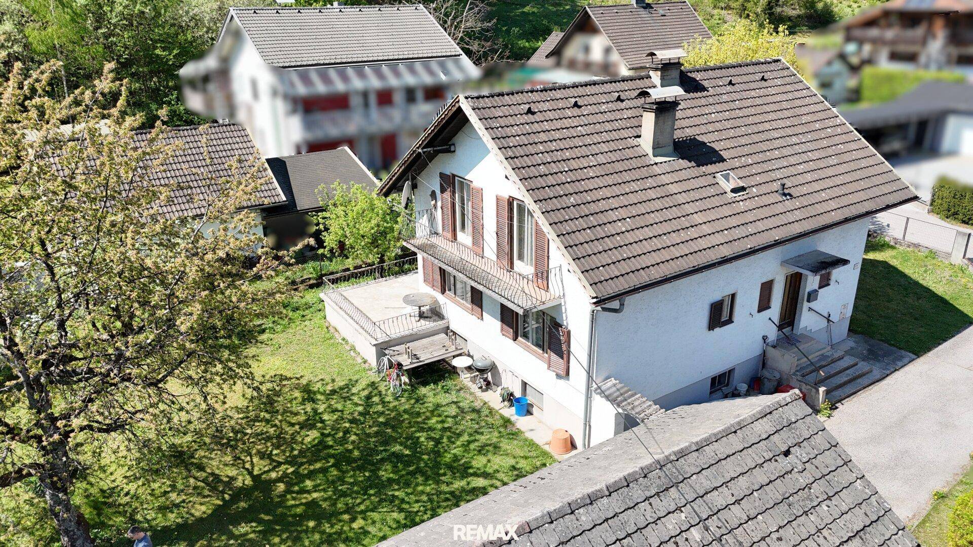 Vogelperspektive des Hauses mit braunem Ziegeldach und einer kleinen Terrasse.