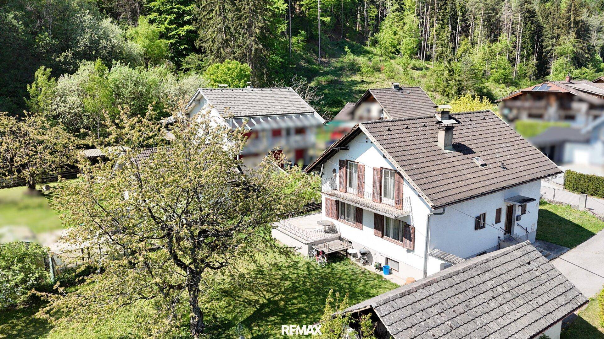 Luftaufnahme des Hauses mit umliegender Natur und dichtem Wald im Hintergrund.