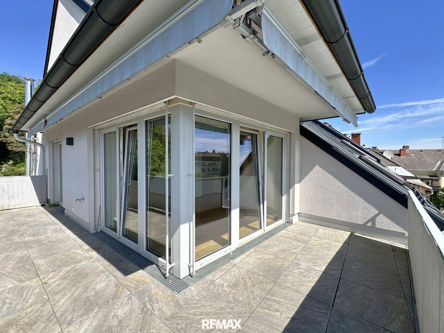 Große Dachterrasse mit Zugang zu den Innenräumen durch breite Glasfronten.