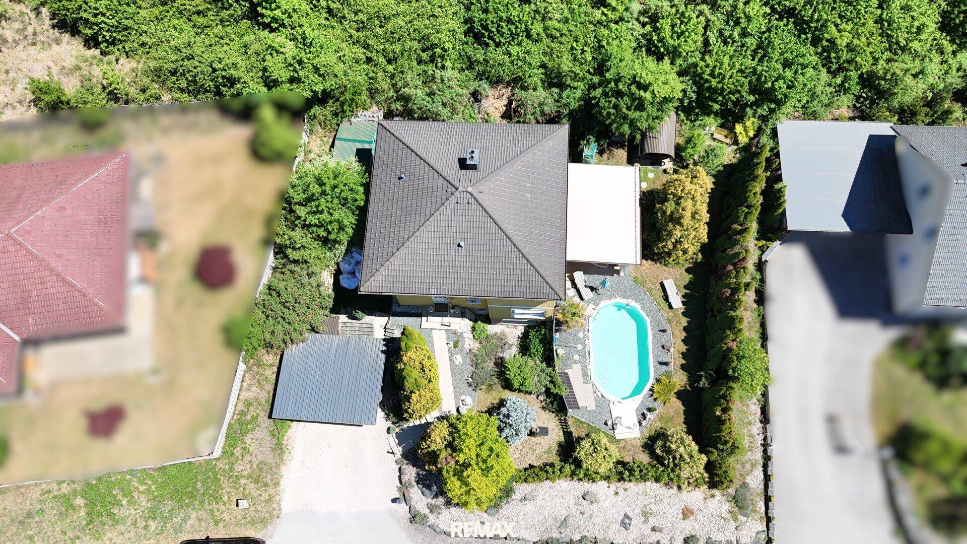 Draufsicht auf das Grundstück mit Haus, Pool und umgebender Vegetation, ideal für Privatsphäre.