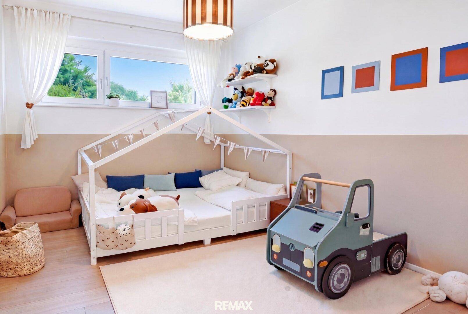 Freundliches Kinderzimmer mit einem einzigartigen Hausbett, Spielzeug und Blick in den Garten.