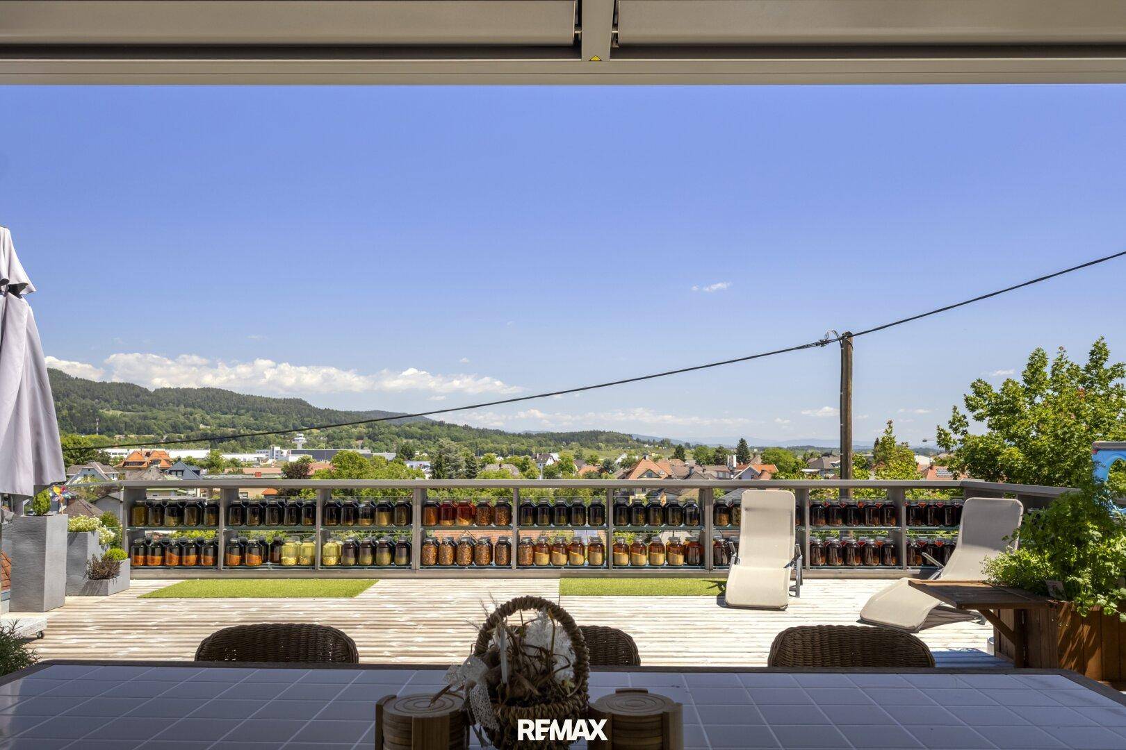Panoramablick von der Terrasse über die weite Landschaft und die umliegende Siedlung.