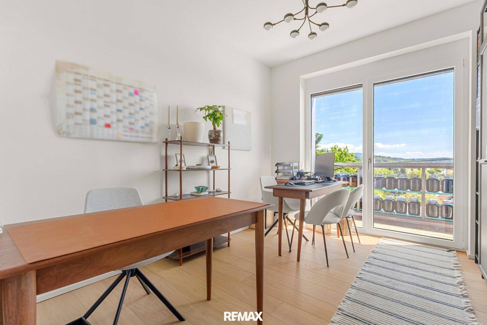 Helles Arbeitszimmer mit zwei Schreibtischen und großem Fenster mit Ausblick.