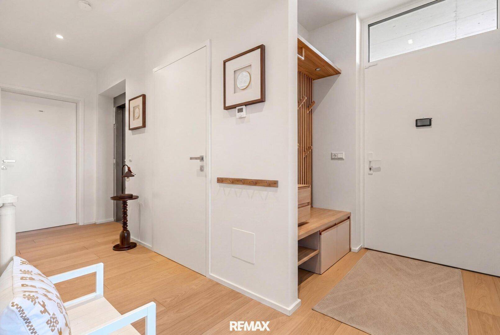 Moderner Eingangsbereich mit Garderobe und hellem Holzboden.