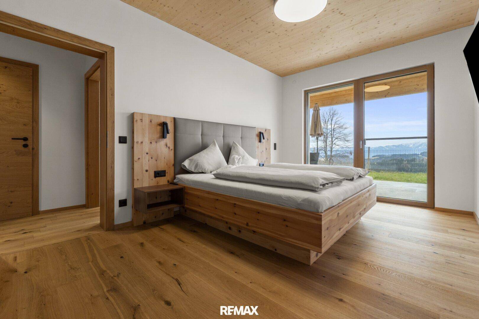 Geräumiges Schlafzimmer mit Holzboden, bequemen Betten und direktem Zugang zur Außenterrasse.