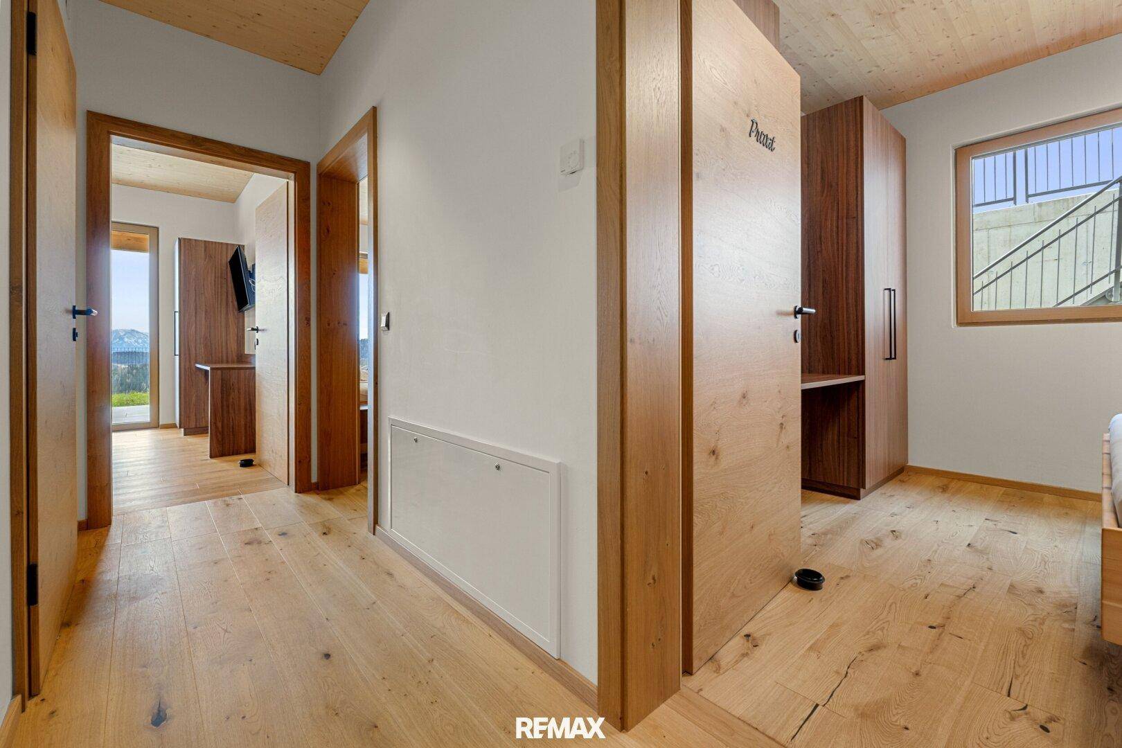 Heller Flur mit Holzboden und Holztüren, der zu den verschiedenen Zimmern führt.