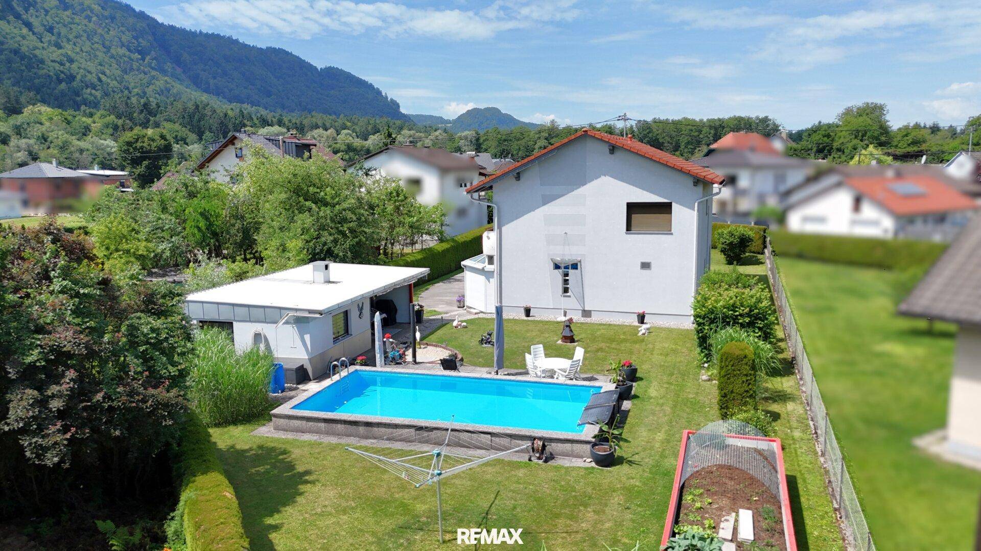 Luftaufnahme des Hauses mit Pool, gepflegtem Garten und kleinem Gemüsegarten.