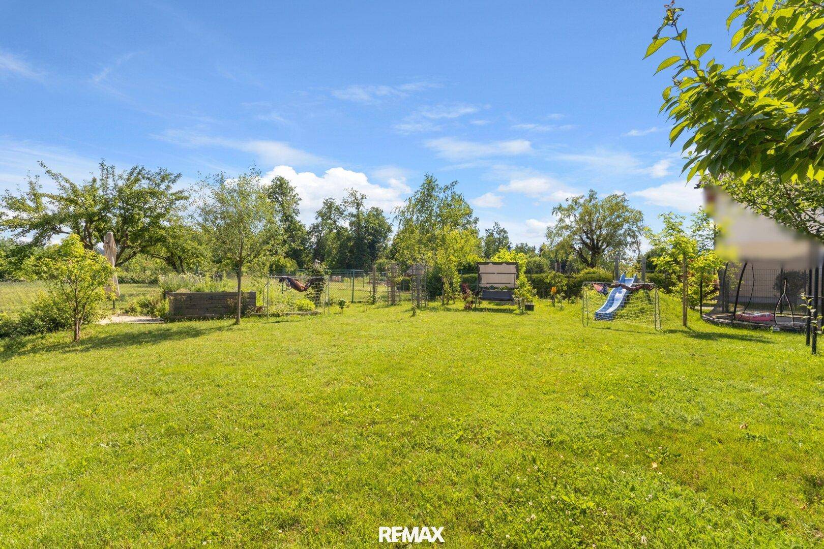 Großer, gepflegter Garten mit Rasenfläche, Bäumen und viel Platz für Freizeitaktivitäten.