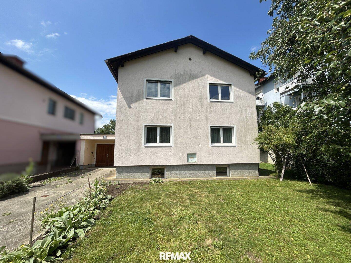 Frontansicht des Hauses mit gepflegtem Rasen und klarem Himmel an einem hellen Tag.