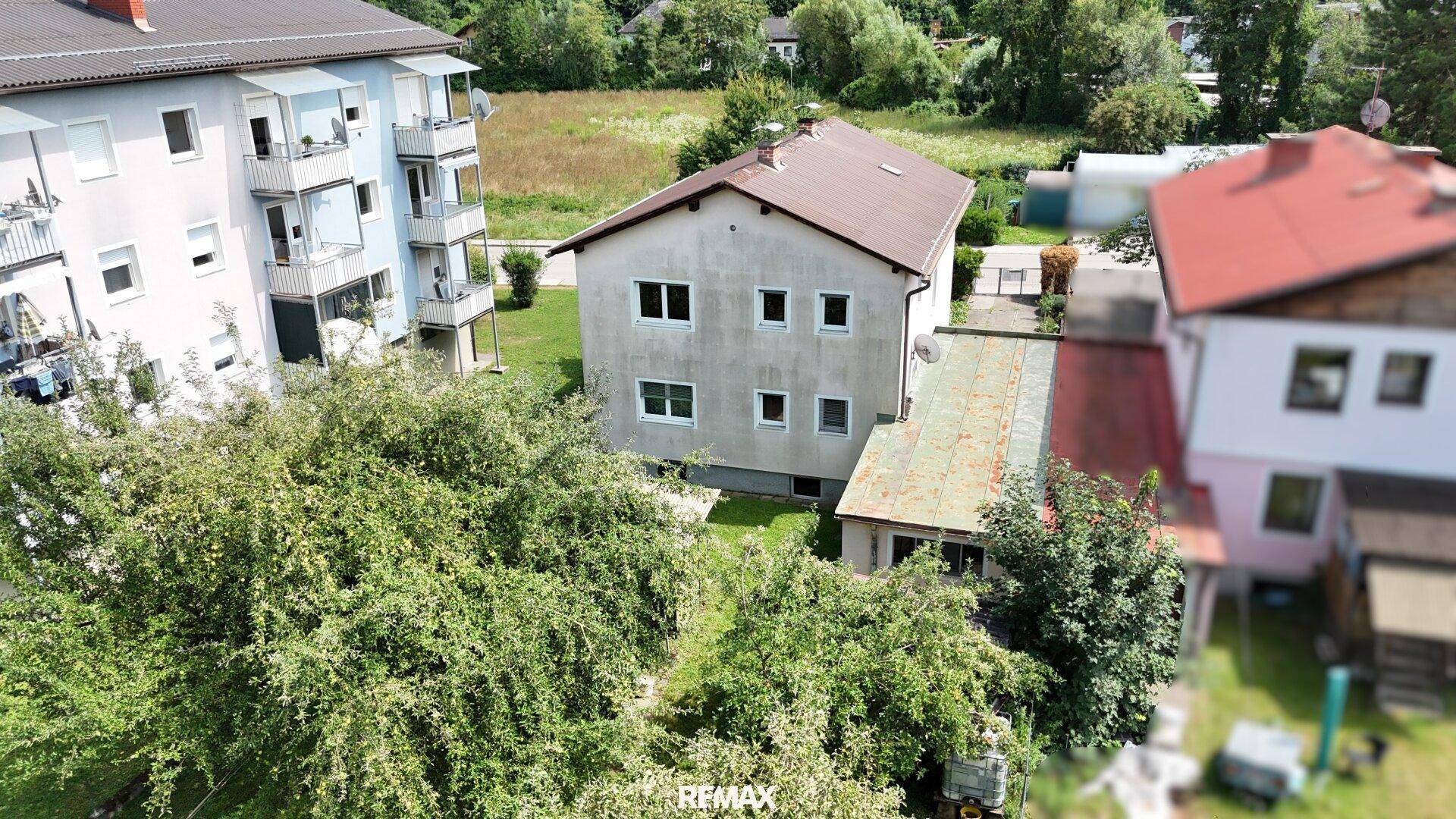 Vogelperspektive des Einfamilienhauses mit großem Garten und umliegenden Bäumen.