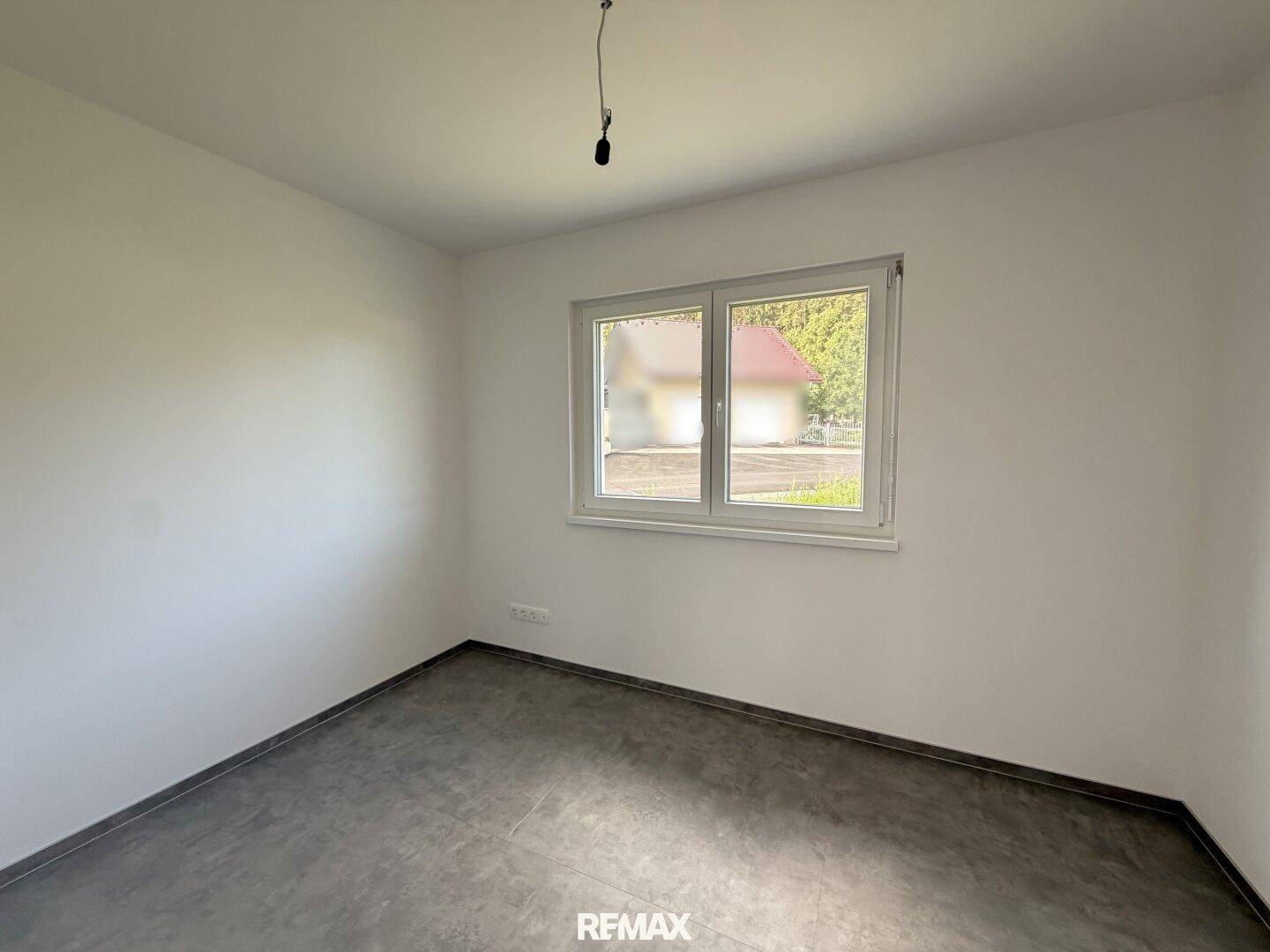 Unmöbliertes Zimmer mit einem Fenster, das einen Blick auf die Umgebung bietet.