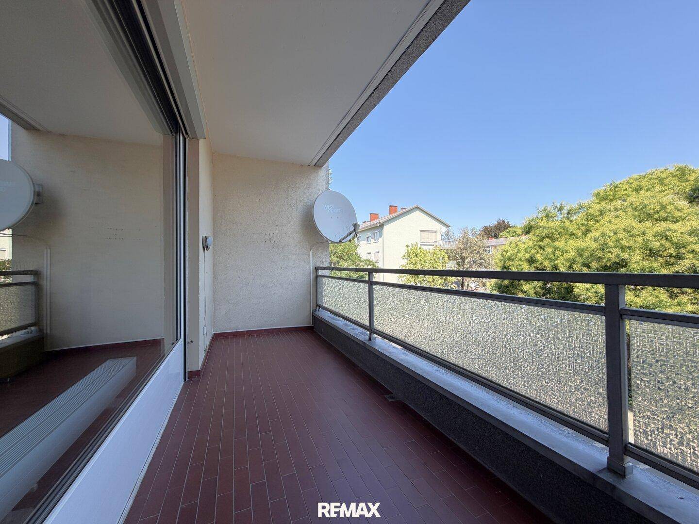 Balkon mit Fliesenboden und Satellitenschüssel, bietet einen weiten Blick in die Umgebung.