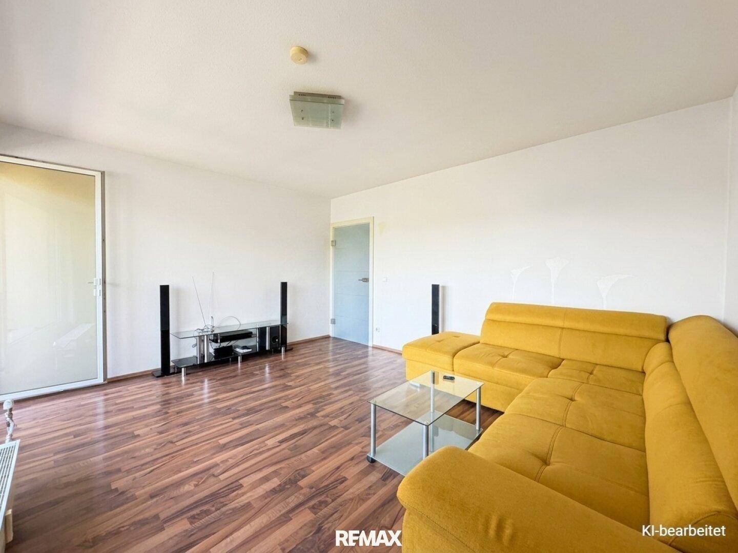 Geräumiges Wohnzimmer mit Laminatboden, gelbem Ecksofa und TV-Möbeln.