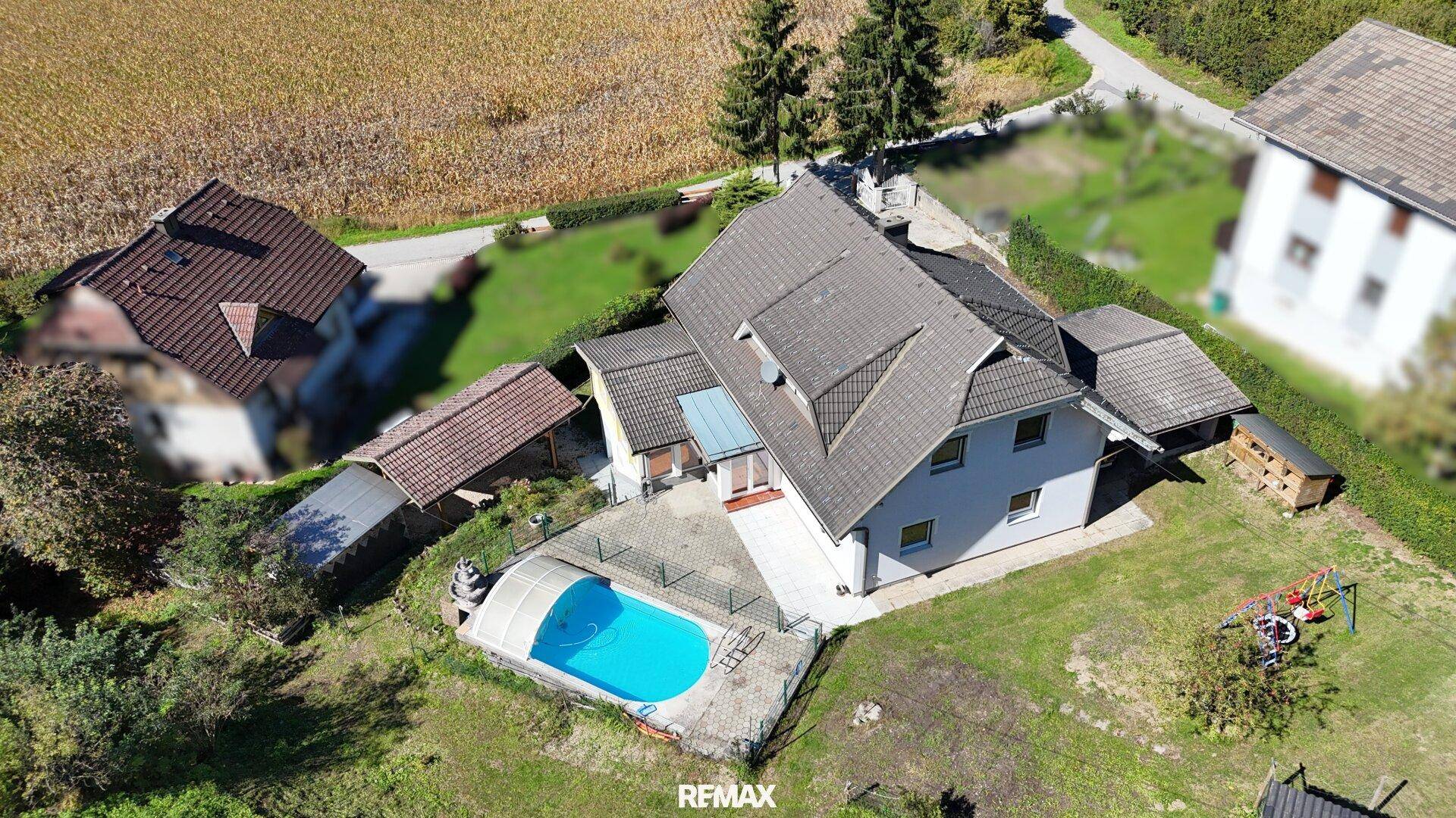Vogelperspektive des Hauses mit Poolbereich, Terrasse und angrenzenden Feldern.