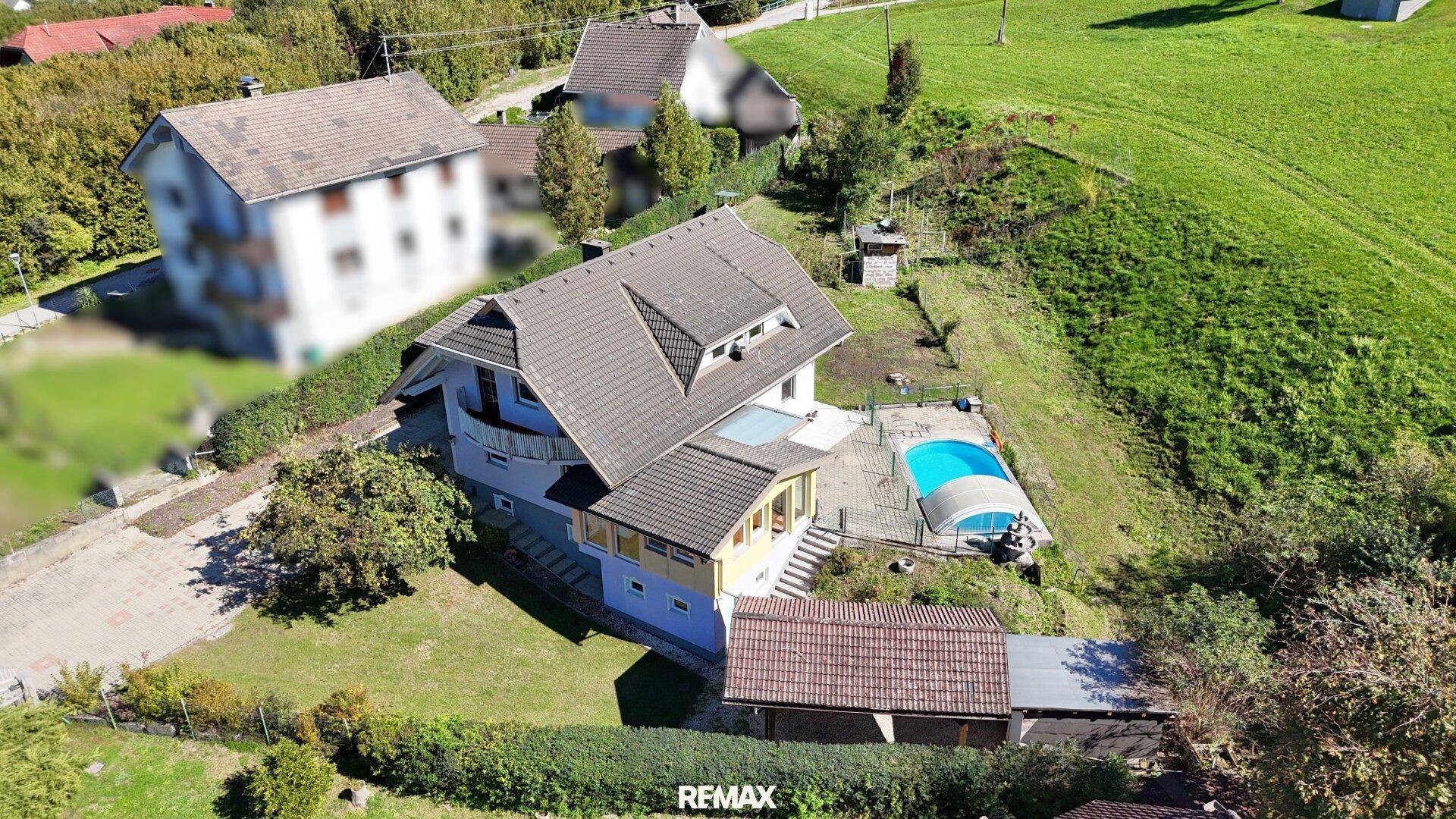 Luftaufnahme des Hauses am Hang mit Poolbereich und weitem Blick über die Landschaft.