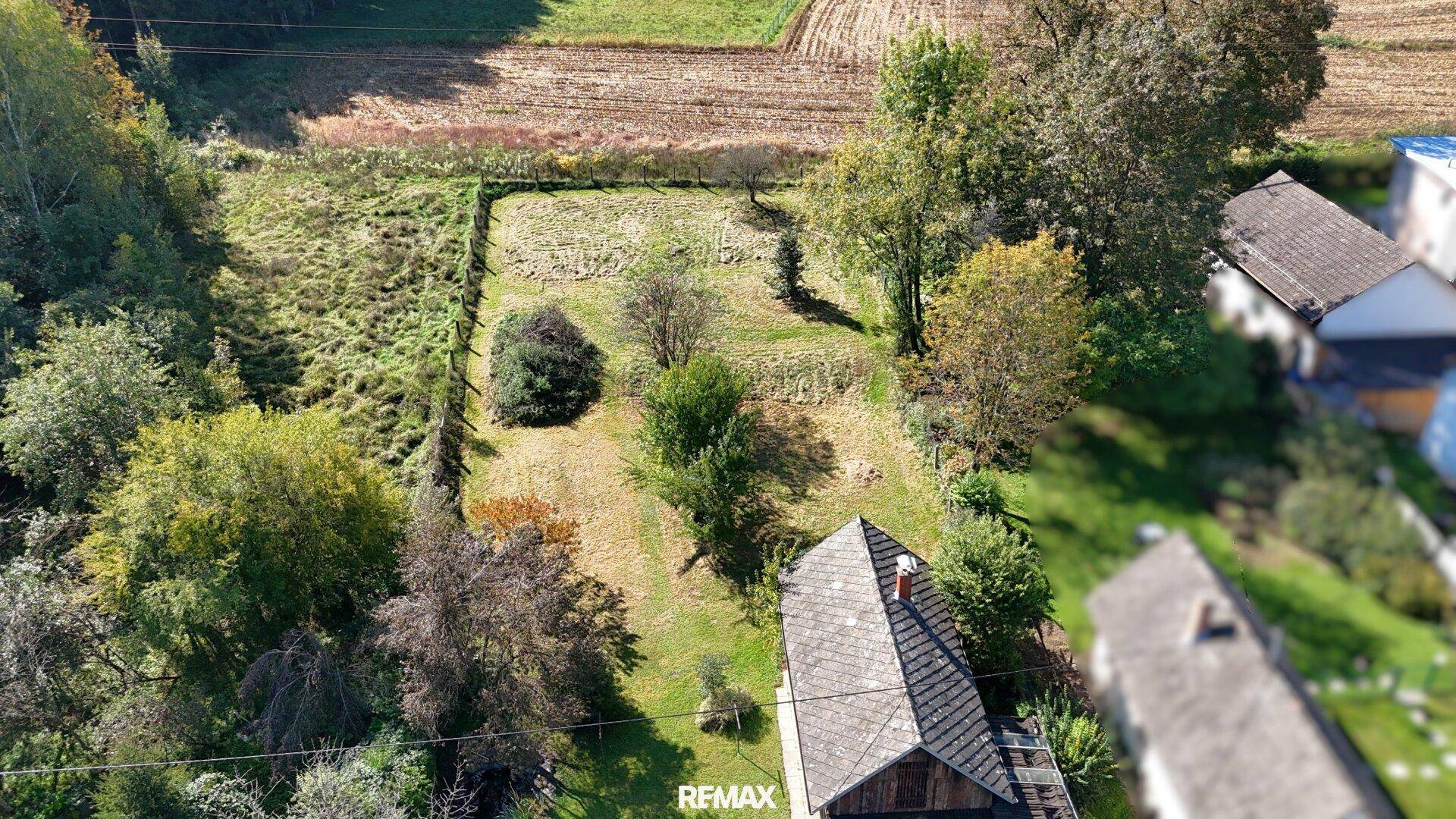 Weitläufige Luftaufnahme des Anwesens mit angrenzenden Feldern und Waldstücken.
