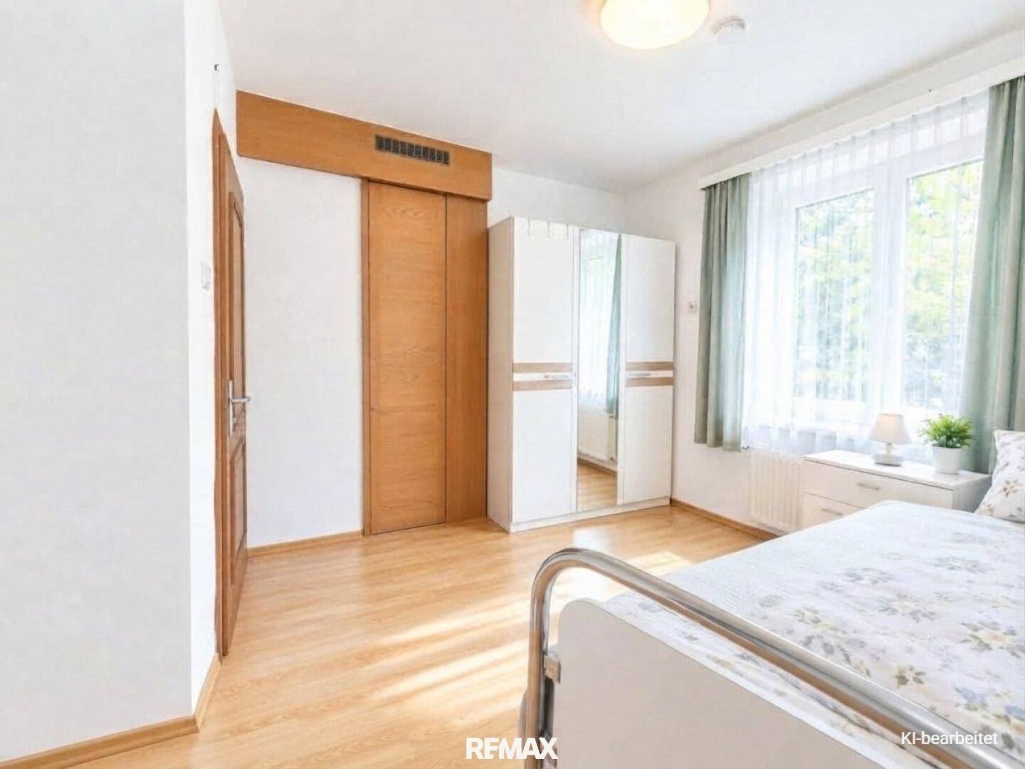 Helles Schlafzimmer mit modernem Kleiderschrank, Holzboden und großem Fenster.