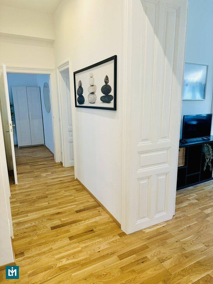 Heller Flur mit Parkettboden und Zugang zu verschiedenen Räumen der Wohnung.