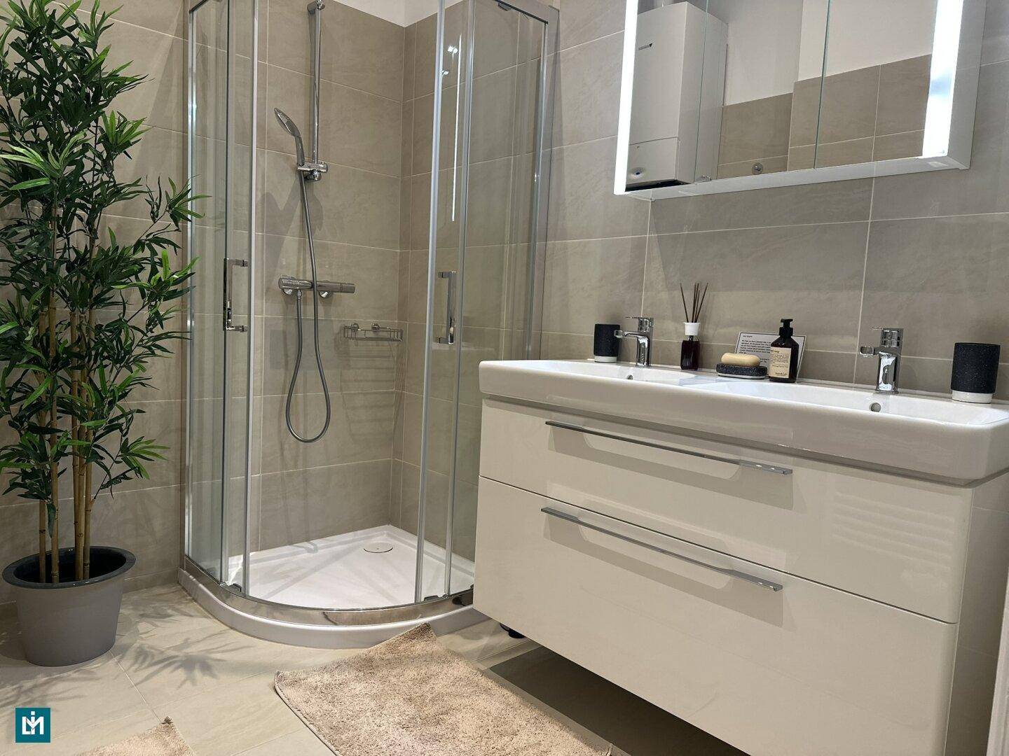 Modernes Badezimmer mit großer Duschkabine, Doppelwaschbecken und hellen Fliesen.