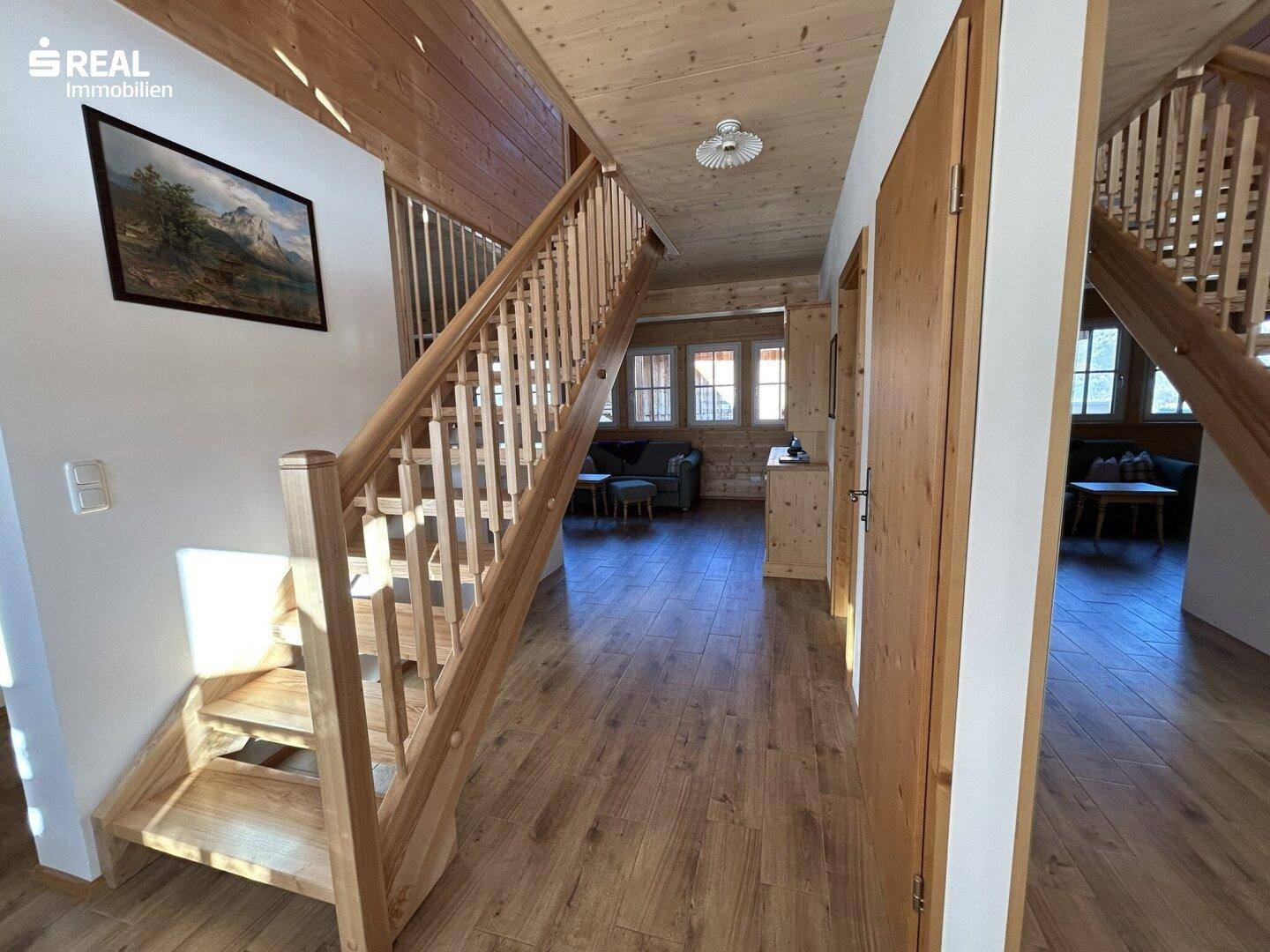 Heller Flur mit Holztreppe und Holzboden, der die verschiedenen Ebenen des Hauses verbindet.
