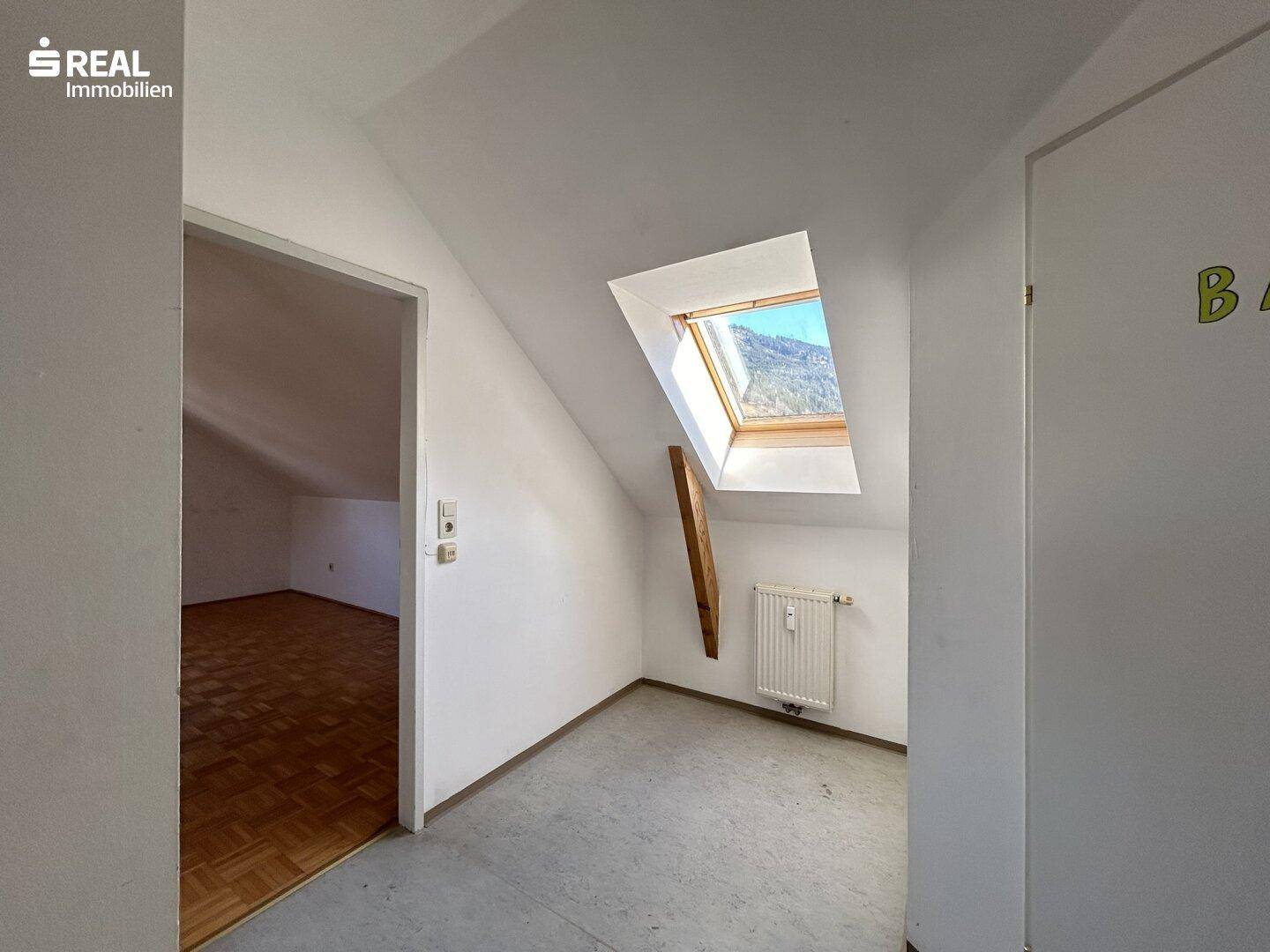 Heller Flur im Dachgeschoss mit Dachfenster und Blick auf die Berge.
